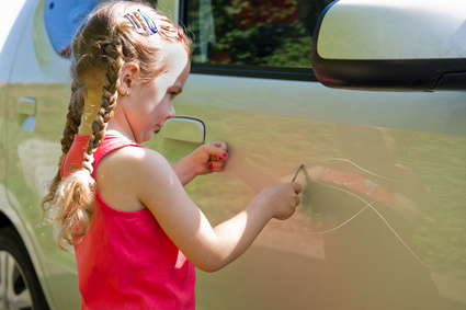 Kind verkratzt ein Auto